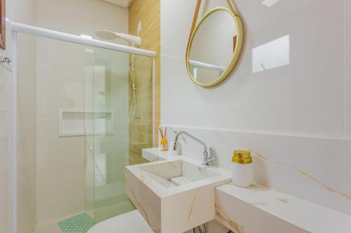 a white bathroom with a sink and a shower at PF26 Excelente Casa 4 Suítes - Praia do Forte in Mata de Sao Joao