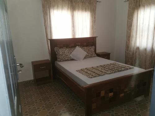 een slaapkamer met een groot bed en een raam bij BARAKAH ESTATE APARTMENTS in Sere Kunda