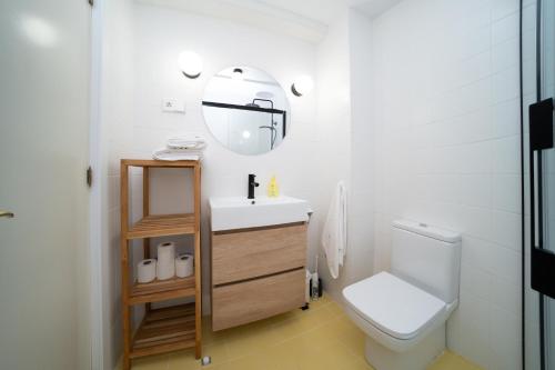 bagno con servizi igienici, lavandino e specchio di Traditional central 2 dbl bed apt in quiet square a Benalmádena