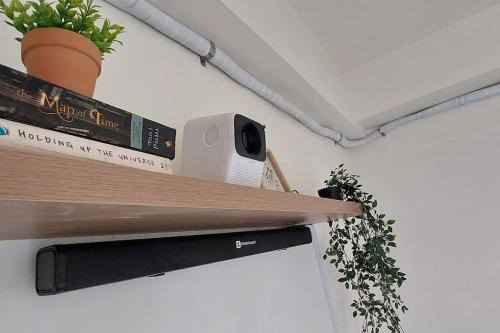 a shelf with books and a speaker and a plant at 2BR Penthouse in Brixton Place with breathtaking view of BGC in Manila