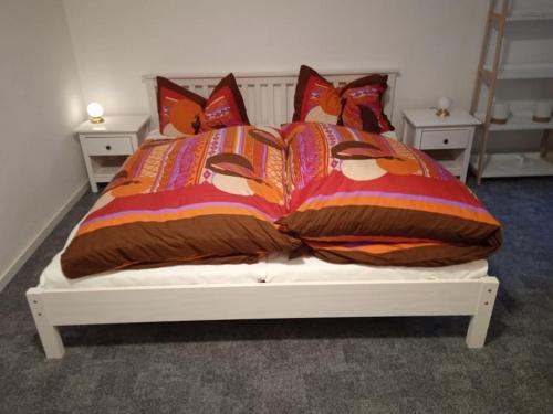 een bed met een kleurrijk dekbed en kussens bij Hexenstube Jorjina - WLAN - Garten- tolles Bad -Wandern -Mountainbike - Motorradurlaub in Braunlage