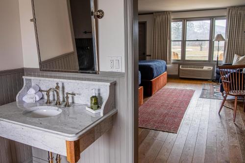 a bathroom with a sink and a living room at Wylder Windham in Windham