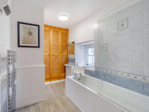 ein weißes Bad mit einer Badewanne und einem Fenster in der Unterkunft 1 Bed in Keswick 86394 in Rosthwaite