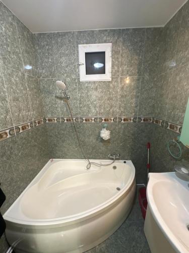 y baño con bañera y lavamanos. en Apartament Sorin, en Tulcea