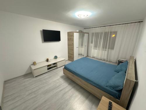 1 dormitorio con 1 cama azul y TV en Apartament Sorin, en Tulcea
