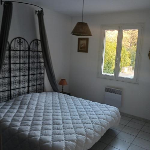 une chambre avec un lit et une fenêtre dans l'établissement Jjflo cadre champêtre, à Signes
