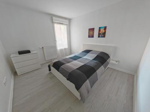 Un dormitorio blanco con una cama y un tocador. en Paris 15 min Appartement tout confort 6 couchages en Vitry-sur-Seine