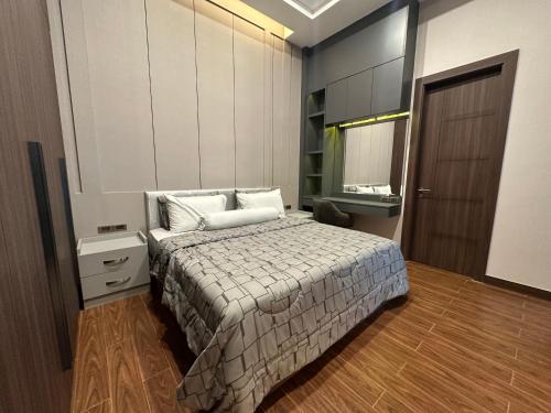 a bedroom with a bed and a dresser and a mirror at Chill Chill Pool Villa Pattaya in Nong Prue