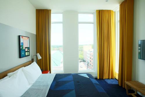 a bedroom with a bed and a large window at The Durham Hotel in Durham