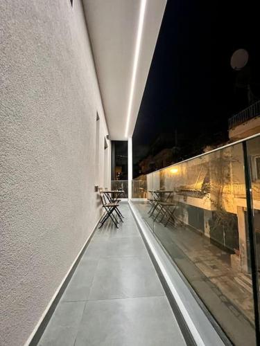 a hallway with tables and chairs on a building at night at Cozy apartment in a new building apartment 2 in Piraeus
