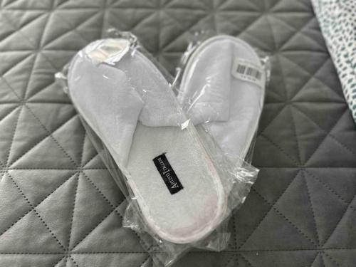 a pair of white shoes in a plastic bag on a bed at Cozy apartment in a new building apartment 2 in Piraeus