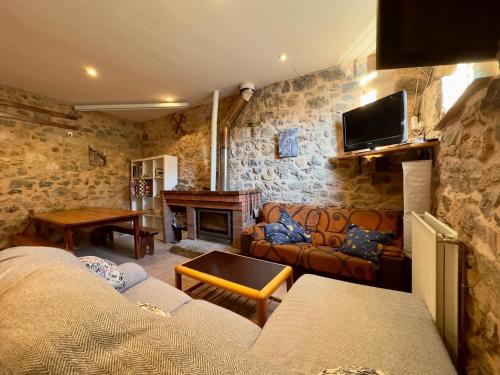 sala de estar con sofá y chimenea en Albergue Valle de Arbas, en Cubillas de Arbas