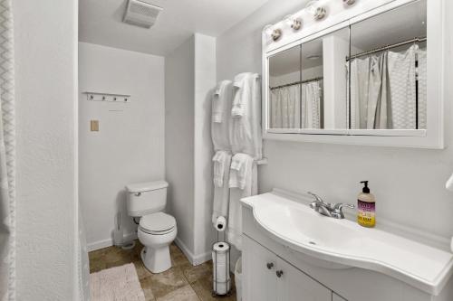 a white bathroom with a toilet and a sink at Paschal Winery - Dream 2 Cottage in Talent
