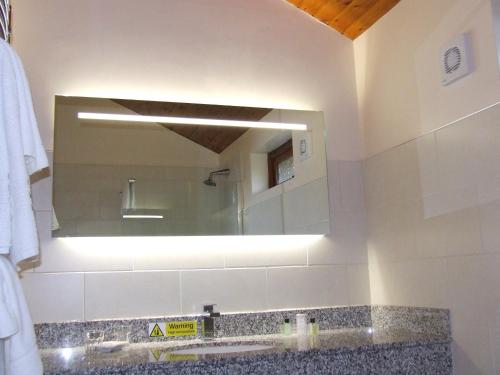 ein Badezimmer mit einem Spiegel und einem Waschbecken in der Unterkunft Calderfields Golf & Country Club in Walsall