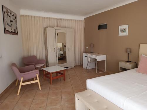 a bedroom with a bed and a chair and a table at Costamar in Lagos