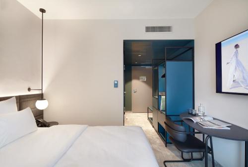 a hotel room with a bed and a desk at Novotel Hamburg Central Station in Hamburg