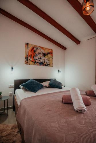 a bedroom with two beds and a painting on the wall at Holiday home Jukan in Vrulje