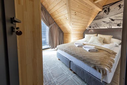 une chambre avec un lit dans un grenier dans l'établissement Domki na Gawlakach, à Zakopane