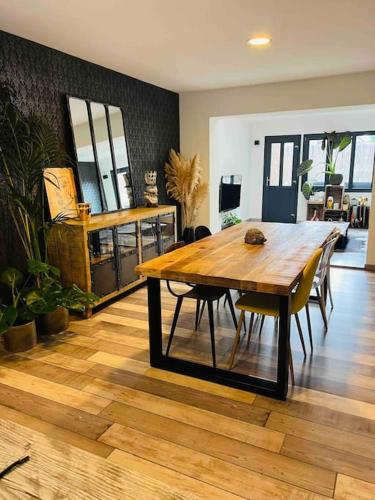 une salle à manger avec une table et des chaises en bois dans l'établissement Jolie maison typique, à Wattrelos