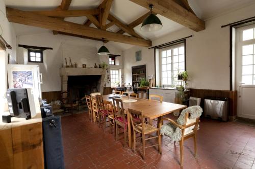 une cuisine et une salle à manger avec une table et des chaises en bois dans l'établissement La maison Benastre, à Saint-Étienne-de-Corcoué