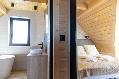 1 dormitorio con cama, lavabo y bañera en Domki na Gawlakach, en Zakopane