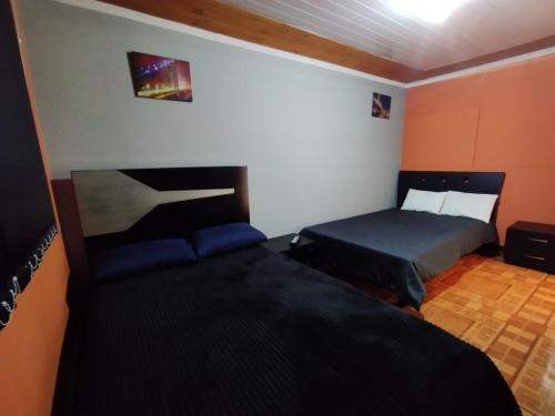 a bedroom with two beds in a room at Habitaciones con baño privada Quiroga in Bogotá