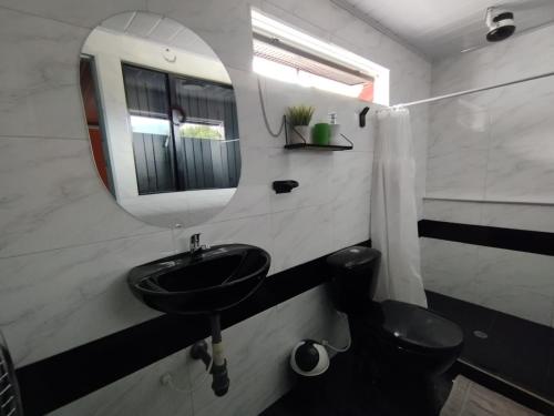 a bathroom with a sink and a mirror and a toilet at Habitaciones con baño privada Quiroga in Bogotá