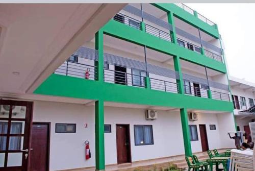 a building with green balconies on the side of it at CELEBRITES HOTEL in Ouidah