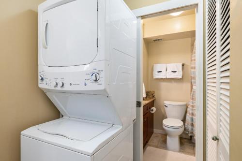 uma casa de banho branca com um WC e um lavatório em 30 Day Rental In Waikiki With Parking! em Honolulu
