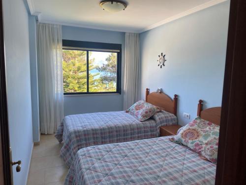 Un pat sau paturi într-o cameră la Apartamentos Playa Langosteira