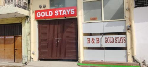 um edifício com uma porta castanha com um sinal em gold stays hotel near IGI international airport em Nova Deli