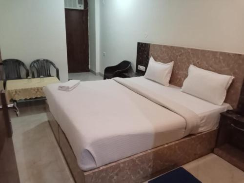 a bedroom with a large white bed in a room at gold stays hotel near IGI international airport in New Delhi