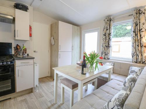 a kitchen and living room with a table and a couch at No 3 Foxburrow Hang in Fritton Norfolk