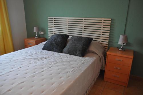 1 dormitorio con 1 cama blanca y 2 mesitas de noche en Near Beach, en Sant Pere Pescador