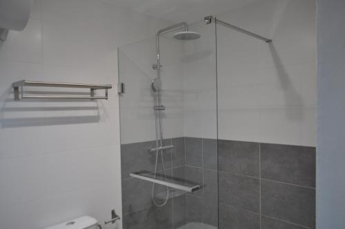 baño con ducha y puerta de cristal en Near Beach, en Sant Pere Pescador