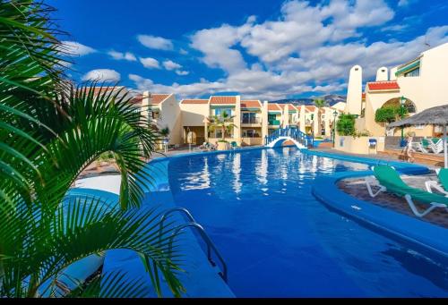 a pool at a resort with a palm tree at House Harvey J53 Mareverde in Adeje