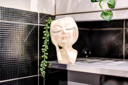 eine Maske auf einem Regal mit einer grünen Pflanze in der Unterkunft Oxford Circus Chic Modern Flat for 4 in London