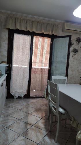 een keuken met twee ramen en een tafel en stoelen bij Casa Amici Miei in Catania