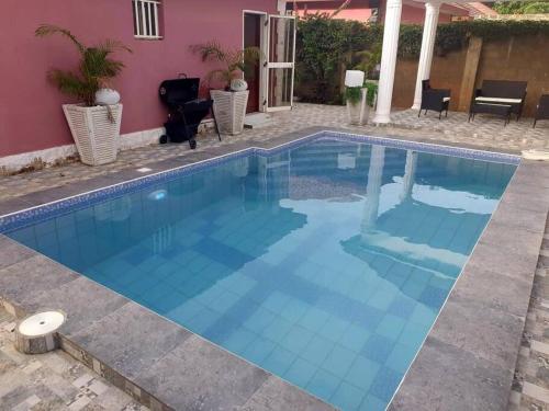 - une piscine dans une villa avec une maison dans l'établissement Poolside Garden, à Brufut