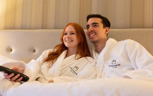 a man and a woman sitting on a bed at The Prince George Hotel in Halifax