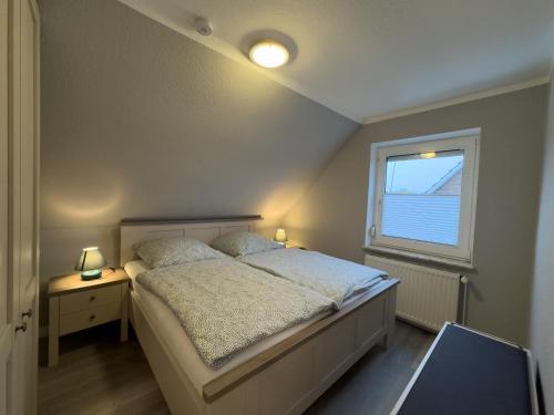 a bedroom with a bed and a window at Windfang 1 in Hooksiel in Wangerland