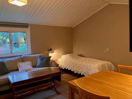 sala de estar con sofá y cama en Stuga i Östhammar, en Östhammar
