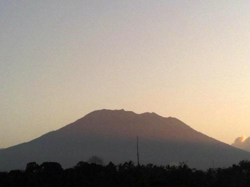 a mountain in the distance with the sun setting behind it at Lila Stana - Sidemen Homestay in Sidemen