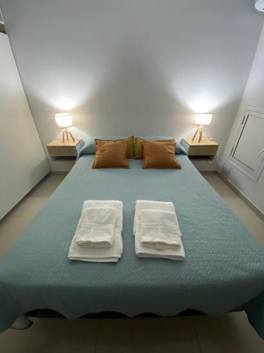 a bedroom with a large bed with two towels on it at Edificio del Sur in Santiago del Estero