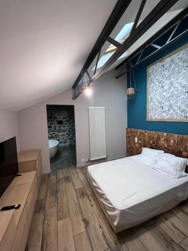 une chambre avec un lit et une salle de bain avec baignoire dans l'établissement Grand loft avec Piscine aux Portes des Cévennes, à Cendras