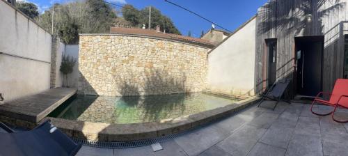 - une piscine dans une cour dotée d'un mur en briques dans l'établissement Grand loft avec Piscine aux Portes des Cévennes, à Cendras