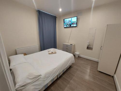 Un pequeño dormitorio con una cama blanca y una ventana en Family friendly 3 Bedroom Flat Zone 2 - children stay free! en Londres