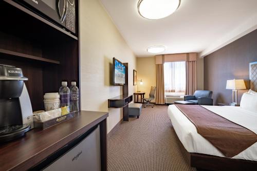 Acclaim Hotel by CLIQUE في كالغاري: غرفه فندقيه سرير وتلفزيون