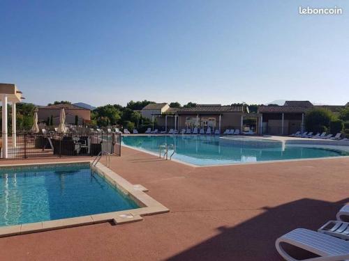 - une grande piscine avec des chaises dans un complexe dans l'établissement Maison de vacances Aubignan, à Aubignan
