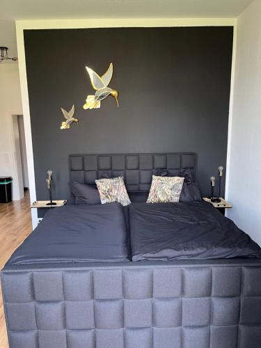 a large bed with two birds on the wall at Cityliebe in Magdeburg